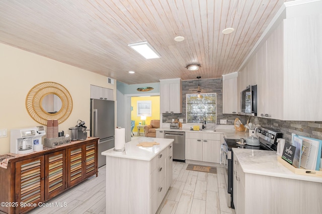303 Winslow Cir, Cocoa Beach, FL 32931 - kitchen featuring appliances with stainless steel finishes, decorative backsplash, light countertops, a center island, and wooden ceiling