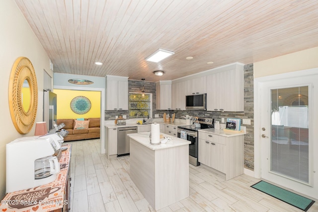 303 Winslow Cir, Cocoa Beach, FL 32931 - kitchen with stainless steel appliances, a center island, light countertops, backsplash, and wood ceiling