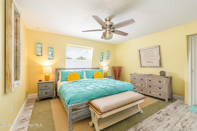 303 Winslow Cir, Cocoa Beach, FL 32931 - bedroom with a textured ceiling, baseboards, light wood-style flooring, and ceiling fan