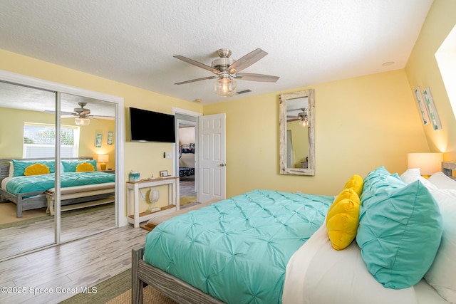 303 Winslow Cir, Cocoa Beach, FL 32931 - bedroom with wood finished floors, a textured ceiling, a closet, and ceiling fan