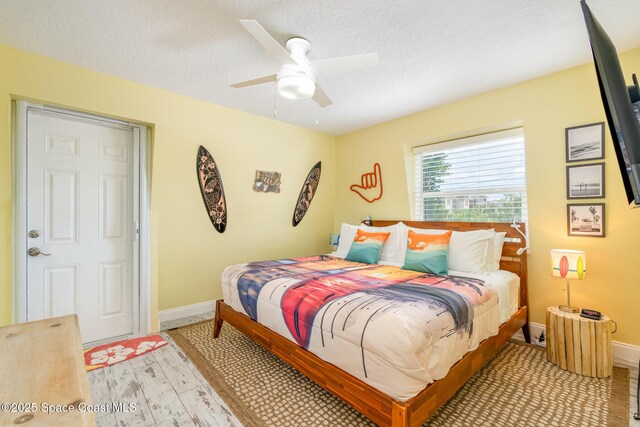 303 Winslow Cir, Cocoa Beach, FL 32931 - bedroom featuring baseboards, light wood-style floors, ceiling fan, and a textured ceiling