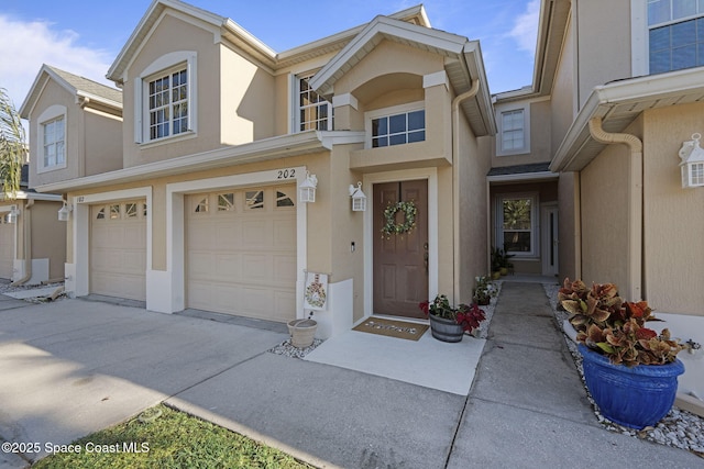 401 Trotter Ln Unit 202, Melbourne, FL 32940 - view of front of home with stucco siding, driveway, and a garage