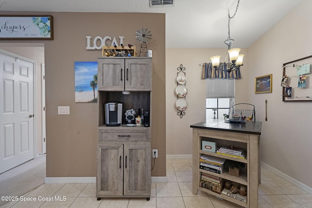 401 Trotter Ln Unit 202, Melbourne, FL 32940 - kitchen with a chandelier, baseboards, pendant lighting, and light tile patterned floors