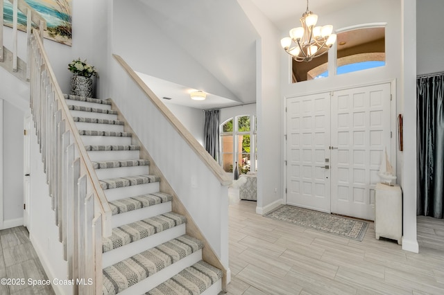4070 S Tropical Trl, Merritt Island, FL 32952 - entrance foyer featuring a chandelier, stairway, baseboards, high vaulted ceiling, and wood finish floors