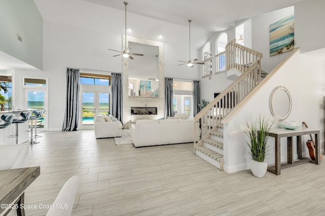 4070 S Tropical Trl, Merritt Island, FL 32952 - living area featuring a ceiling fan, a high ceiling, baseboards, and stairway