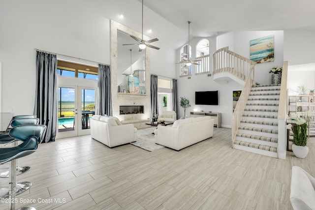 4070 S Tropical Trl, Merritt Island, FL 32952 - living area featuring a ceiling fan, a high ceiling, stairway, and a fireplace