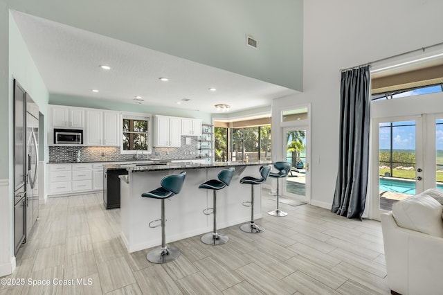 4070 S Tropical Trl, Merritt Island, FL 32952 - kitchen with built in appliances, plenty of natural light, a kitchen breakfast bar, backsplash, and recessed lighting