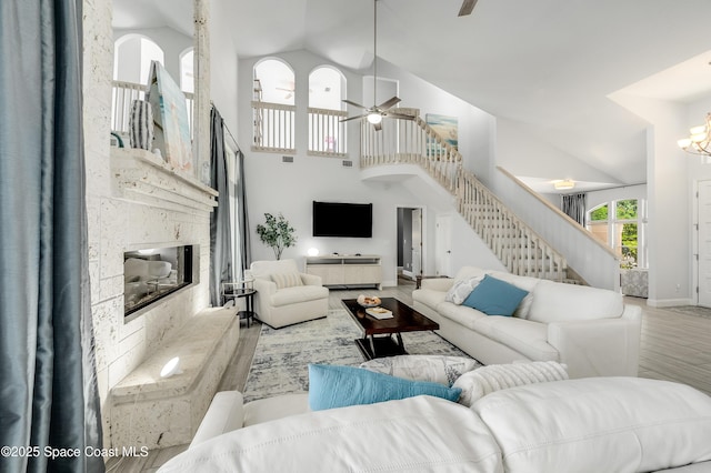 4070 S Tropical Trl, Merritt Island, FL 32952 - living room with stairs, high vaulted ceiling, a high end fireplace, wood finished floors, and ceiling fan
