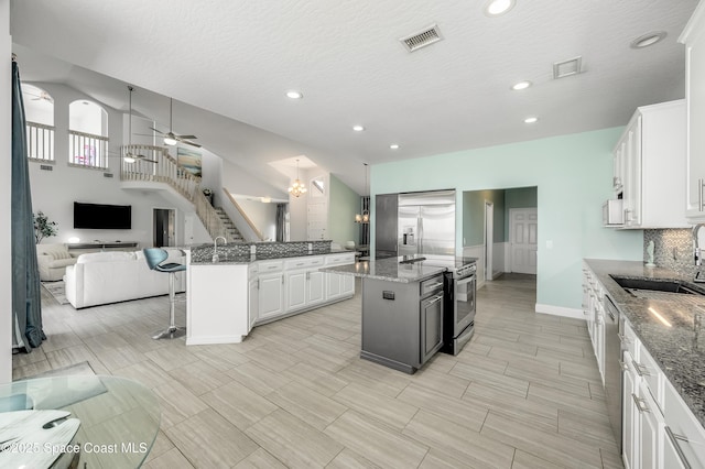 4070 S Tropical Trl, Merritt Island, FL 32952 - kitchen featuring stainless steel appliances, a sink, open floor plan, a center island, and baseboards