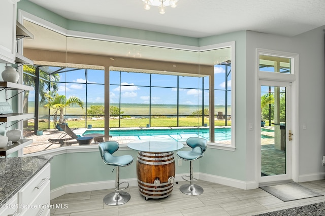 4070 S Tropical Trl, Merritt Island, FL 32952 - kitchen with white cabinets, dark stone counters, and baseboards