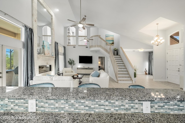 4070 S Tropical Trl, Merritt Island, FL 32952 - living area featuring high vaulted ceiling, stairs, ceiling fan, a chandelier, and baseboards