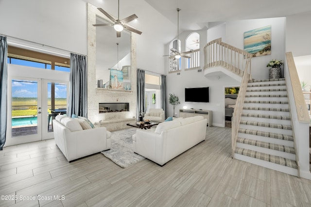 4070 S Tropical Trl, Merritt Island, FL 32952 - living area featuring a ceiling fan, high vaulted ceiling, french doors, stairs, and plenty of natural light