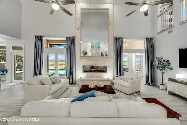 4070 S Tropical Trl, Merritt Island, FL 32952 - living room with a ceiling fan, a high ceiling, a large fireplace, and baseboards