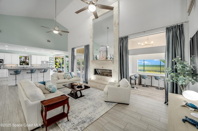 4070 S Tropical Trl, Merritt Island, FL 32952 - living room with high vaulted ceiling, ceiling fan, healthy amount of natural light, a large fireplace, and a chandelier