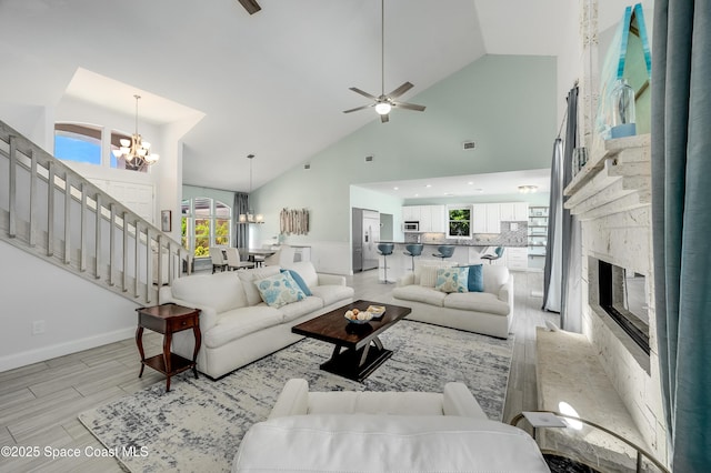 4070 S Tropical Trl, Merritt Island, FL 32952 - living area with a chandelier, stairs, a premium fireplace, high vaulted ceiling, and a ceiling fan