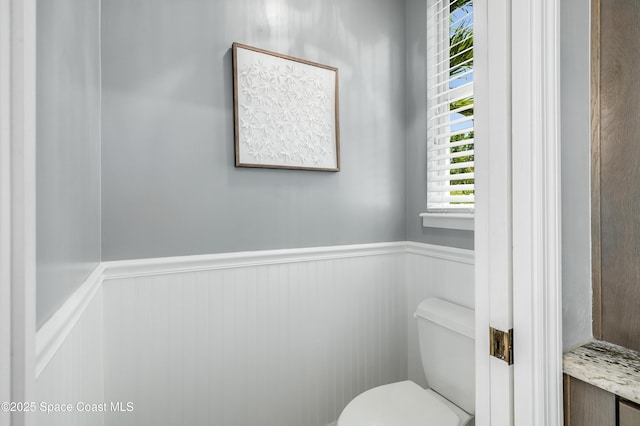 4070 S Tropical Trl, Merritt Island, FL 32952 - bathroom with a wainscoted wall and toilet
