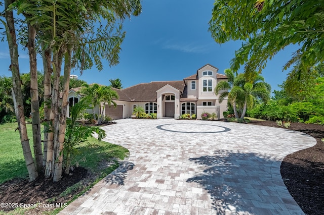 4070 S Tropical Trl, Merritt Island, FL 32952 - view of front facade with curved driveway, stucco siding, a tiled roof, and a garage