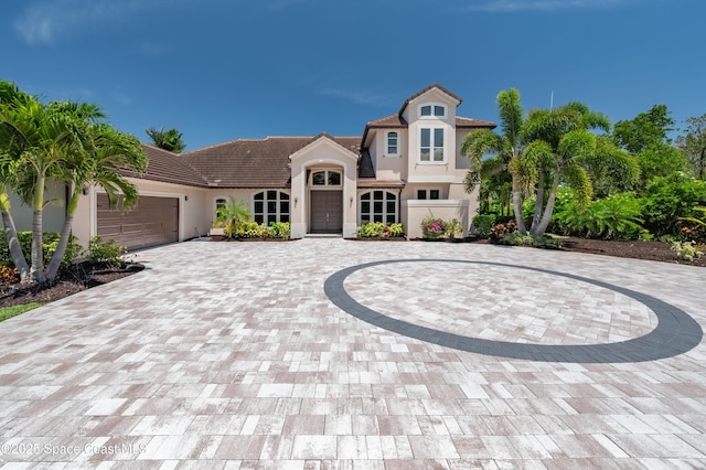4070 S Tropical Trl, Merritt Island, FL 32952 - mediterranean / spanish house with curved driveway, stucco siding, a tiled roof, and an attached garage