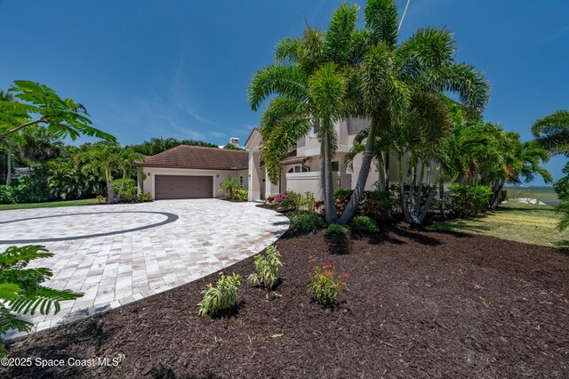 4070 S Tropical Trl, Merritt Island, FL 32952 - mediterranean / spanish house with decorative driveway, stucco siding, a tiled roof, and an attached garage