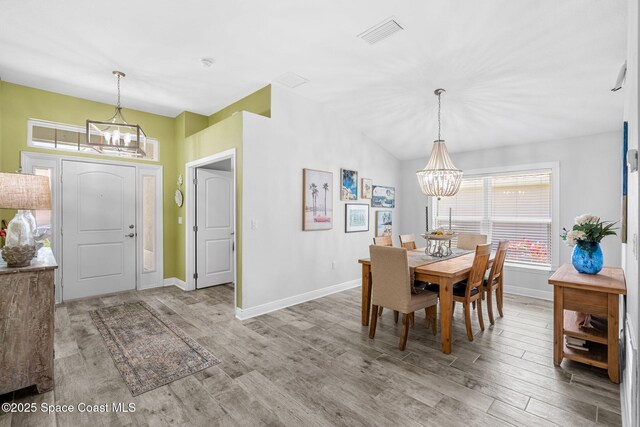 439 Briarcliff Cir, Sebastian, FL 32958 - dining room with a chandelier, wood finished floors, baseboards, and vaulted ceiling