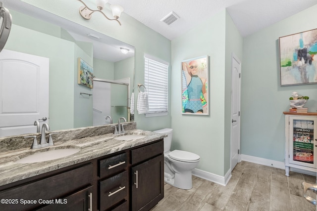 439 Briarcliff Cir, Sebastian, FL 32958 - bathroom featuring a stall shower, toilet, wood finished floors, double vanity, and baseboards