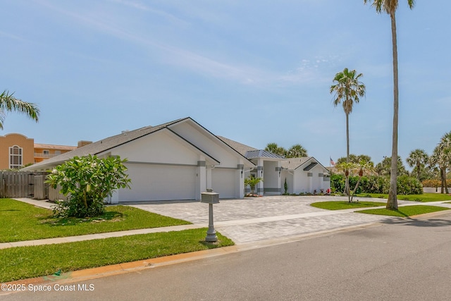 100 Martesia Way, Indian Harbour Beach, FL 32937 - ranch-style home with an attached garage, decorative driveway, and stucco siding