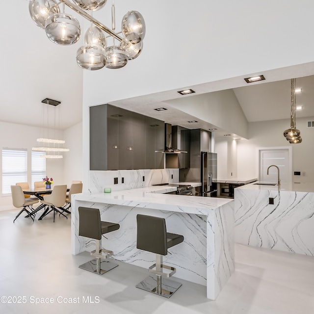 100 Martesia Way, Indian Harbour Beach, FL 32937 - kitchen featuring wall chimney exhaust hood, modern cabinets, a sink, light stone counters, and pendant lighting