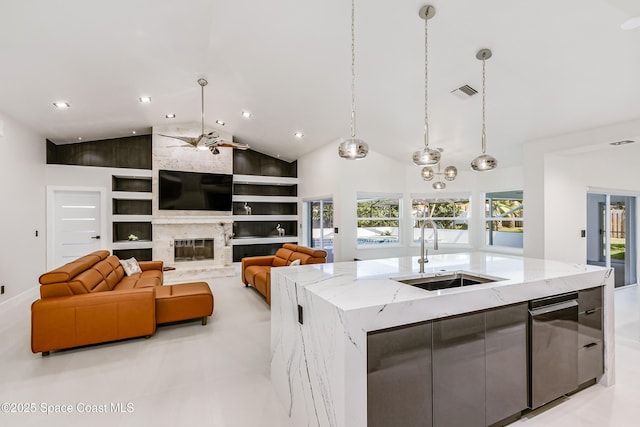 100 Martesia Way, Indian Harbour Beach, FL 32937 - kitchen featuring a sink, built in features, an island with sink, hanging light fixtures, and light stone countertops