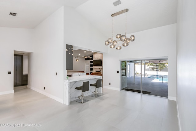 100 Martesia Way, Indian Harbour Beach, FL 32937 - unfurnished dining area featuring high vaulted ceiling, a chandelier, and baseboards