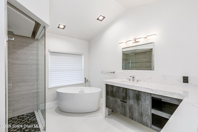 100 Martesia Way, Indian Harbour Beach, FL 32937 - bathroom with vaulted ceiling, a soaking tub, vanity, and a stall shower