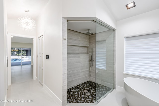 100 Martesia Way, Indian Harbour Beach, FL 32937 - bathroom with a shower stall, a freestanding tub, a chandelier, and baseboards