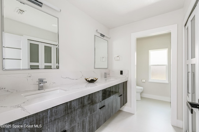 100 Martesia Way, Indian Harbour Beach, FL 32937 - full bath featuring toilet, double vanity, and baseboards