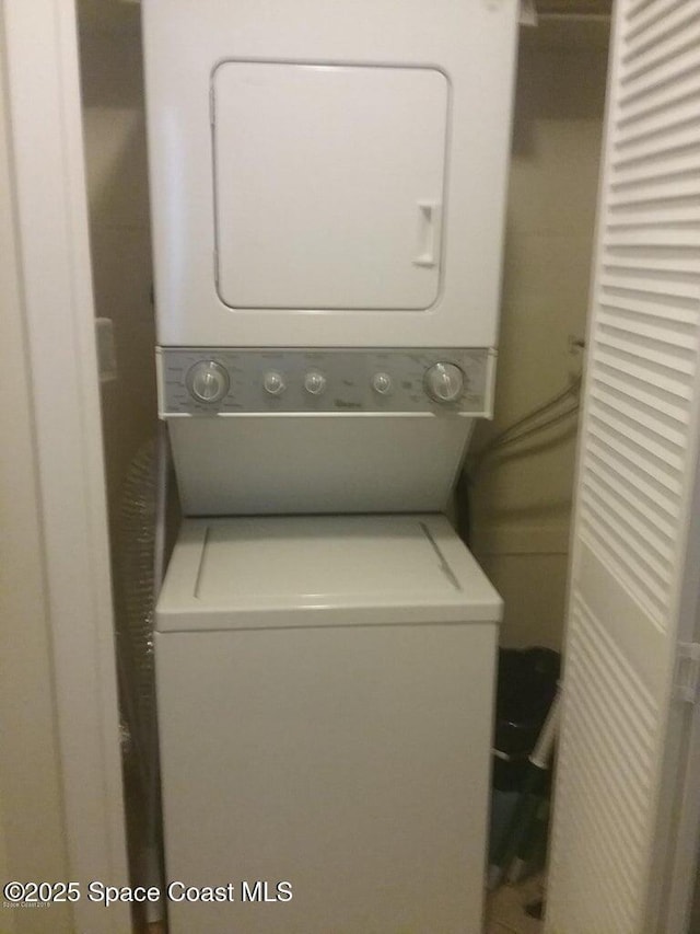clothes washing area featuring stacked washer and clothes dryer