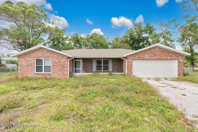 ranch-style house with an attached garage, brick siding, driveway, and fence