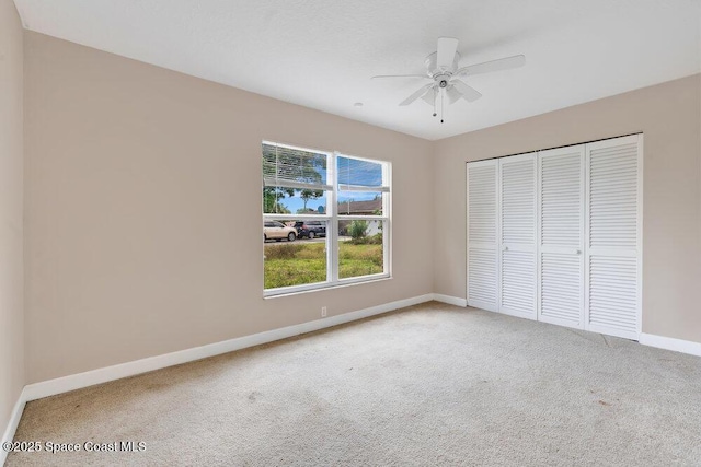 unfurnished bedroom with carpet floors, baseboards, a closet, and ceiling fan