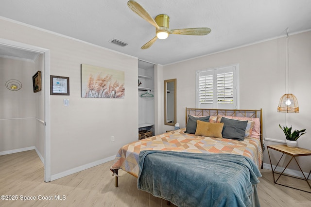 bedroom with wood finished floors, ornamental molding, baseboards, and a ceiling fan