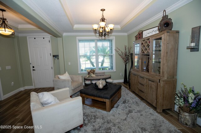 4407 Preservation Cir, Melbourne, FL 32934 - living area featuring a chandelier, wood finished floors, baseboards, a tray ceiling, and ornamental molding