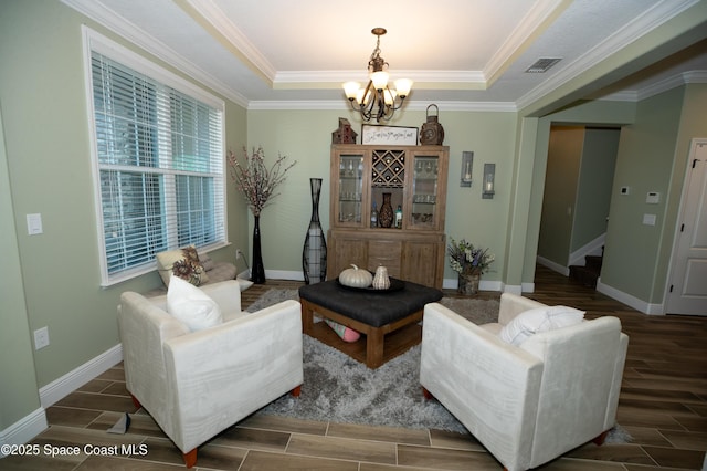 4407 Preservation Cir, Melbourne, FL 32934 - living area featuring a chandelier, wood finish floors, a raised ceiling, baseboards, and crown molding