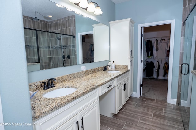 4407 Preservation Cir, Melbourne, FL 32934 - bathroom with a shower stall, double vanity, a spacious closet, and wood finish floors