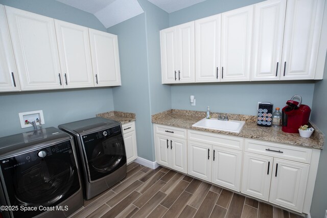 4407 Preservation Cir, Melbourne, FL 32934 - washroom featuring cabinet space, washer and clothes dryer, dark wood finished floors, and baseboards