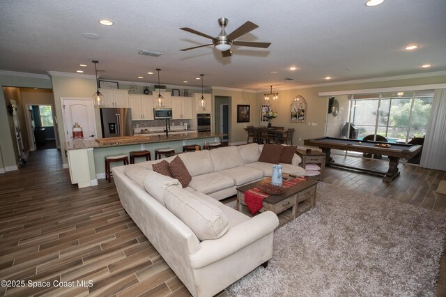 4407 Preservation Cir, Melbourne, FL 32934 - living room featuring crown molding, plenty of natural light, wood finished floors, ceiling fan, and recessed lighting