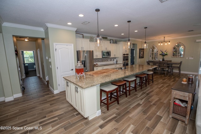 4407 Preservation Cir, Melbourne, FL 32934 - kitchen with appliances with stainless steel finishes, baseboards, a kitchen breakfast bar, dark wood-style flooring, and crown molding
