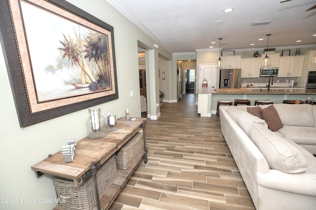 4407 Preservation Cir, Melbourne, FL 32934 - living area featuring crown molding, light wood-type flooring, recessed lighting, and baseboards
