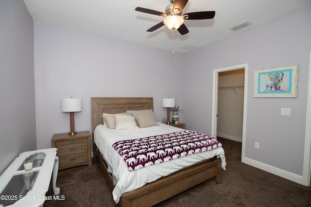 4407 Preservation Cir, Melbourne, FL 32934 - bedroom with dark carpet, a walk in closet, a closet, baseboards, and ceiling fan