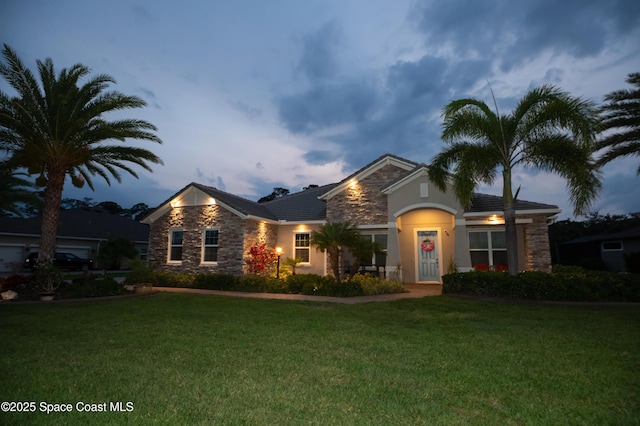 4407 Preservation Cir, Melbourne, FL 32934 - view of front facade featuring stone siding, a front lawn, and stucco siding