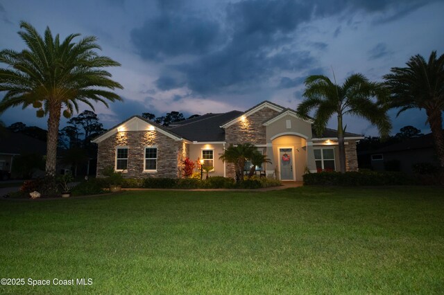 4407 Preservation Cir, Melbourne, FL 32934 - view of front facade featuring stone siding, a front yard, and stucco siding
