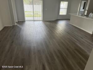 1611 Tugwell Ave, Palm Bay, FL 32909 - unfurnished living room with dark wood-style flooring and baseboards