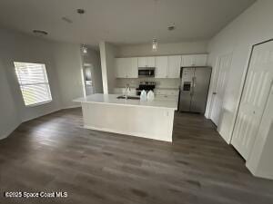 1611 Tugwell Ave, Palm Bay, FL 32909 - kitchen with appliances with stainless steel finishes, white cabinets, light countertops, and dark wood-type flooring
