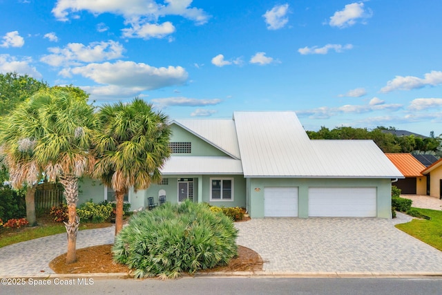 430 Monaco Dr, Indialantic, FL 32903 - view of front facade featuring an attached garage, stucco siding, decorative driveway, and metal roof