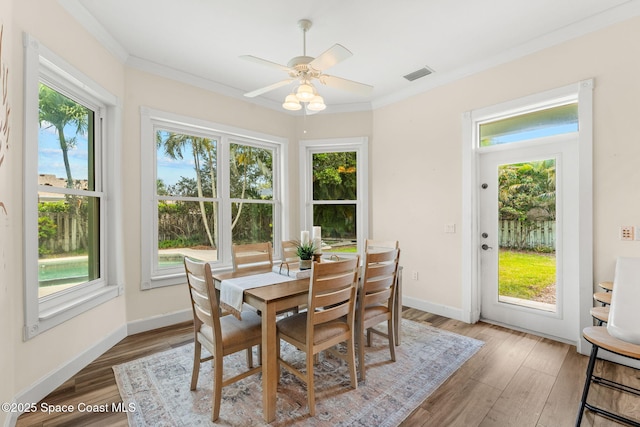 430 Monaco Dr, Indialantic, FL 32903 - dining area featuring healthy amount of natural light, light wood finished floors, ceiling fan, crown molding, and baseboards